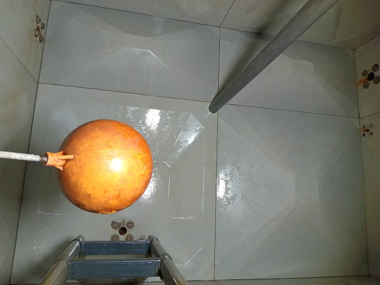 Rooftop tank after cleaning — clean tiled interior surfaces, no discolouration, ready for refill
